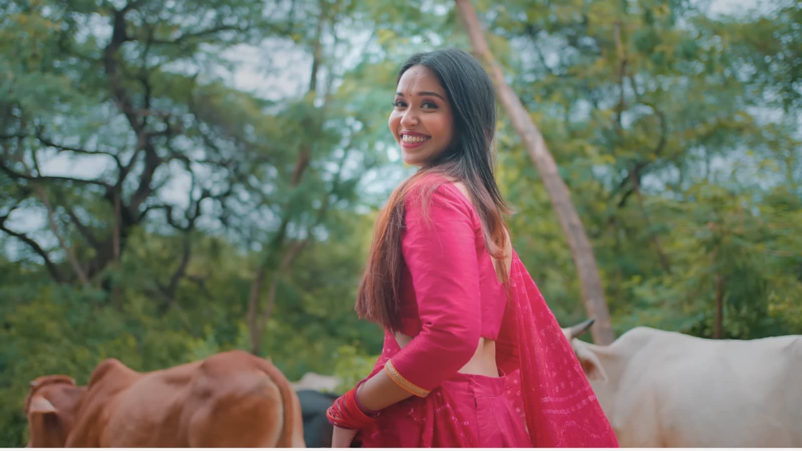 Aishwarya Anand at a live concert event, microphone in hand, smiling at audience